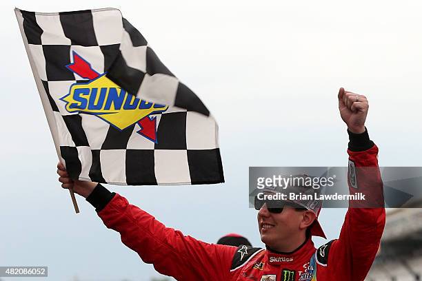 Kyle Busch, driver of the Skittles Toyota, celebrates with the checkered flag after winning the NASCAR Sprint Cup Series Crown Royal Presents the...