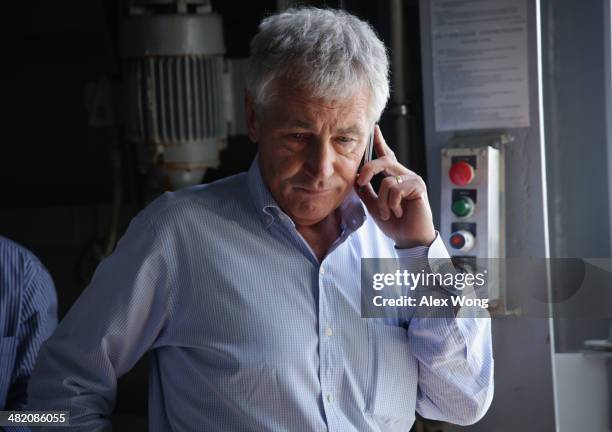 Secretary of Defense Chuck Hagel receives an update on the phone after a report of a shooting at Ft. Hood, Texas, while he is touring the the USS...