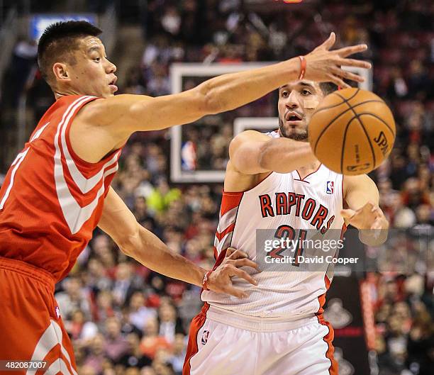 Toronto Raptors guard Greivis Vasquez make a pass as he is guarded by Houston Rockets guard Jeremy Lin during the first half of the game between...