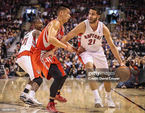 Toronto Raptors guard Greivis Vasquez looks to pass as he is guarded by Houston Rockets guard Jeremy Lin during the first half of the game between...