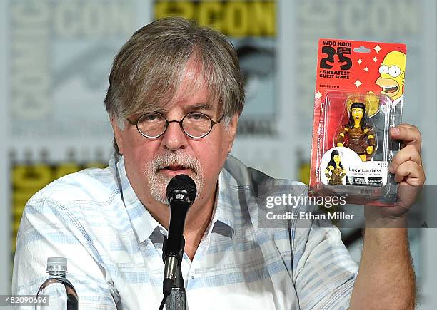 Producer/writer Matt Groening gives away a Lucy Lawless figure as he attends "The Simpsons" panel during Comic-Con International 2015 at the San...