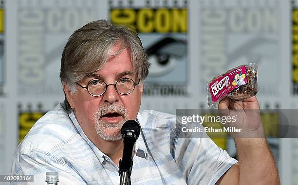 Producer/writer Matt Groening gives away a Krusty Klump bar as he attends "The Simpsons" panel during Comic-Con International 2015 at the San Diego...