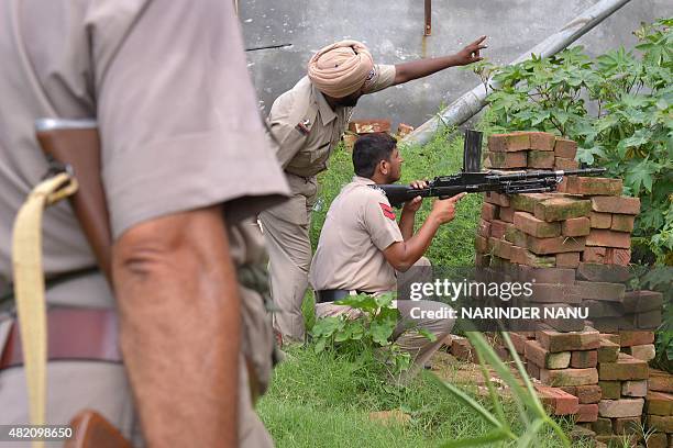 Indian Punjab police personnel take position during an encounter with armed attackers at the police station in Dinanagar town, in the Gurdaspur...