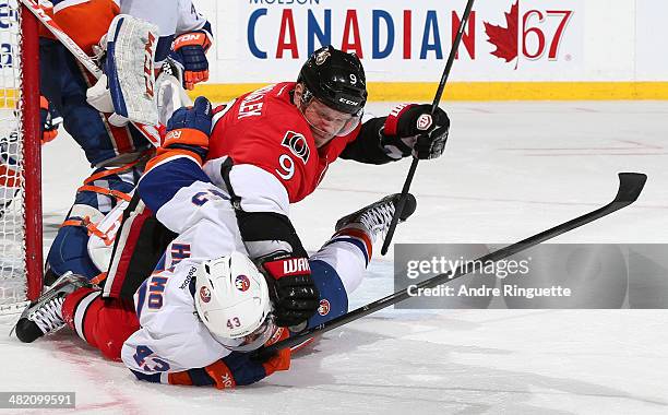 Milan Michalek of the Ottawa Senators shoves Mike Halmo of the New York Islanders to the ice after the two got tangled up at Canadian Tire Centre on...