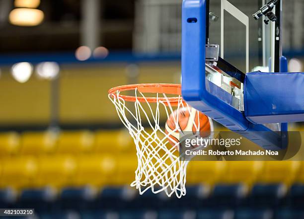 Toronto 2015 Pan Am or Pan American Games, women basketball: A Molten ball entering the net or bucket in a basketball court with empty seats.