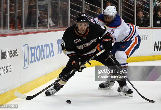 Kyle Palmieri of the Anaheim Ducks is checked by Mark Fraser of the Edmonton Oilers in the first period at Honda Center on April 2, 2014 in Anaheim,...