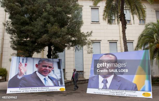 Man walks near photographs of Ethiopian Prime Minister Hailemariam Desalegn and US President Barack Obama outside the National Palace in Addis Ababa...