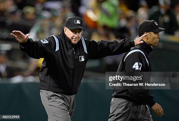 First Base umpire and crew chief Mike Winters after a review, reverses an out call to safe for Mike Aviles of the Cleveland Indians who stole second...