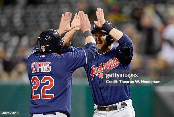 Ryan Raburn and Jason Kipnis of the Cleveland Indians celebrate after they both scored on a two-run single from Michael Brantley against the Oakland...