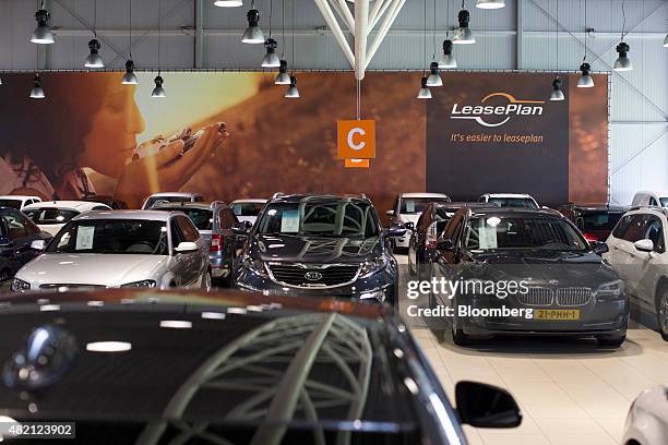 The LeasePlan Corp. Logo sits on a sign as automobiles sit on display inside the company's used car leasing and contract hire showroom in Breukelen,...