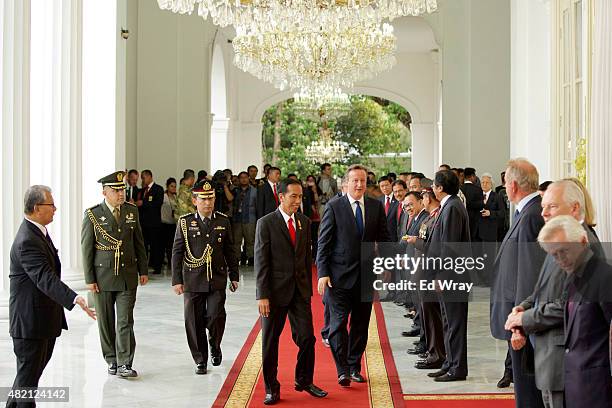 Indonesian President Joko Widodo, left and British Prime Minister David Cameron chat as they walk to a bilateral meeting at the Presidential Palace...