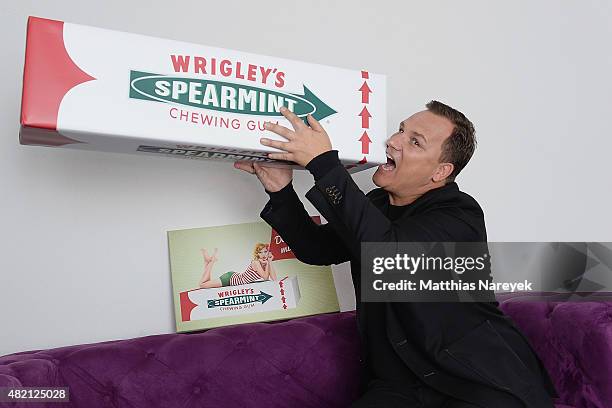Guido Maria Kretschmer poses with his newly designed clutch for Wrigley's Spearmint on July 27, 2015 in Berlin, Germany.
