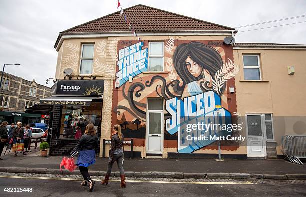 People pass a piece of street art by the artist Inkie as part of the ongoing Upfest 2015 festival being held in Bedminster on July 27, 2015 in...