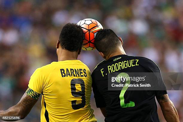 Giles Barnes of Jamaica and Francisco Javier Rodriguez of Mexico battle for a head ball in the first half during the CONCACAF Gold Cup Final at...
