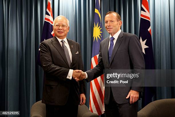 Malaysian Prime Minister Najib Razak and Australian Prime Minister Tony Abbott shake hands during a bilateral meeting at the Commonwealth Parliament...