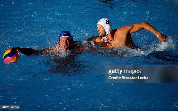 Rustam Ukumanov of Kazakhstan is challenged by Marton Szivos of Hungary in the Men's Water Polo Preliminary Round group C match between Hungary and...