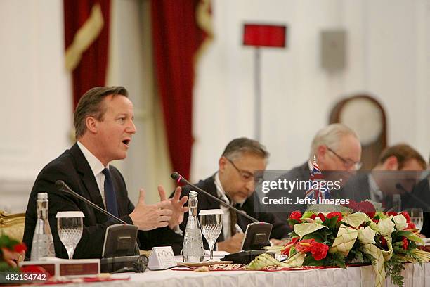 British Prime Minister David Cameron speaks, as British Ambassador to Indonesia, Moazzam Malik listens during bilateral meetings at the Presidential...