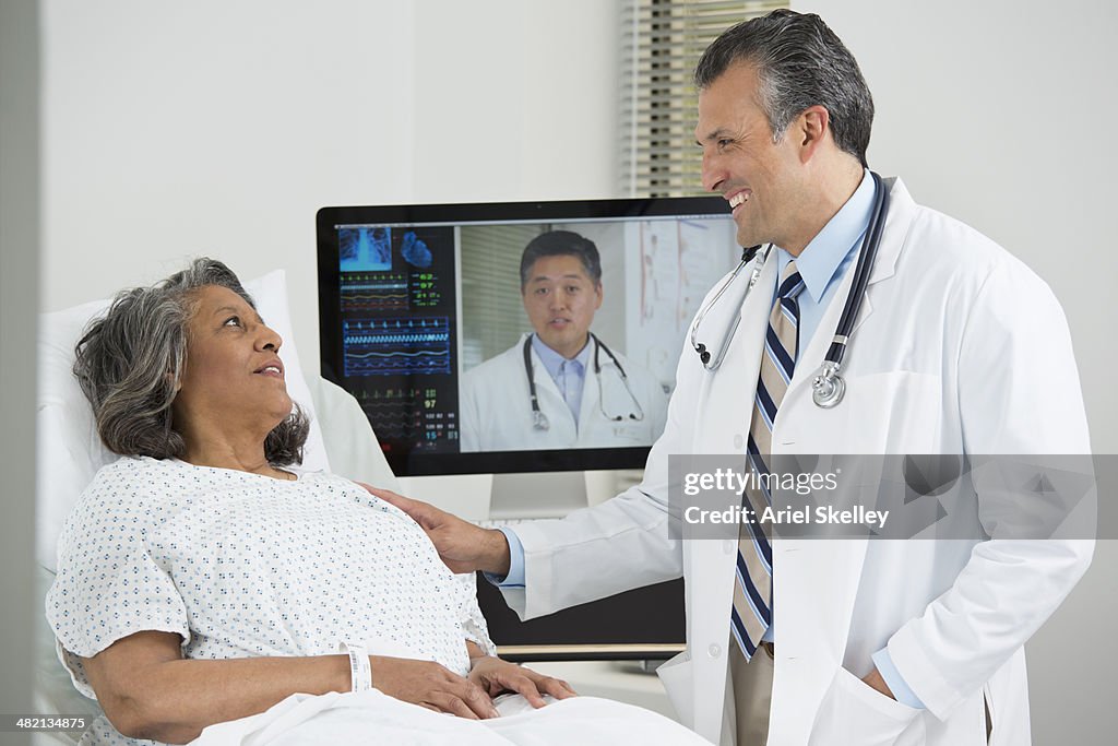 Doctors having teleconference with patient in hospital