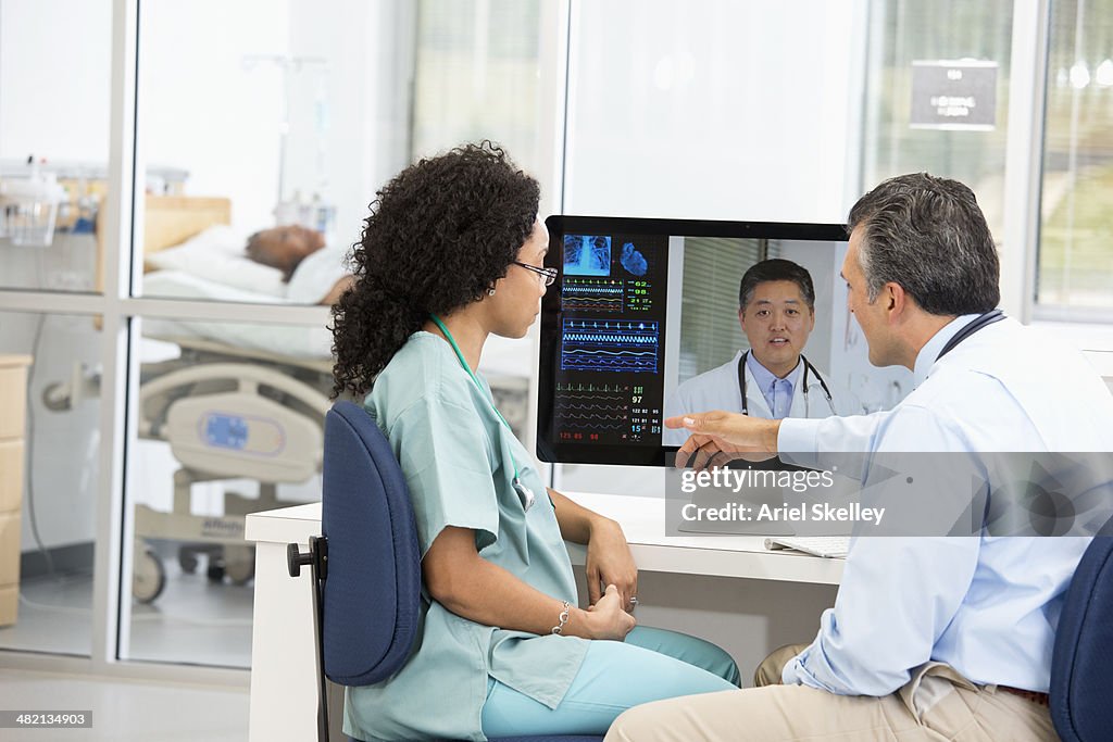 Nurse having teleconference with doctors in hospital