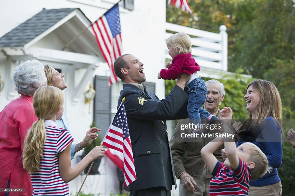 Caucasian family greeting returning soldier