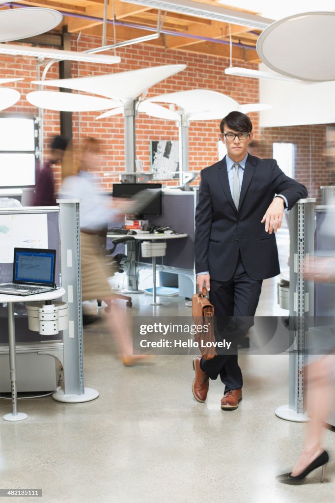 Businessman standing in busy office