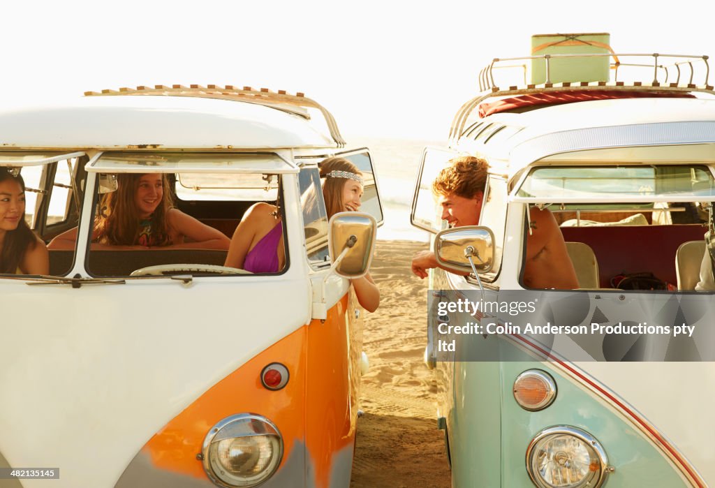 People talking in vans on beach