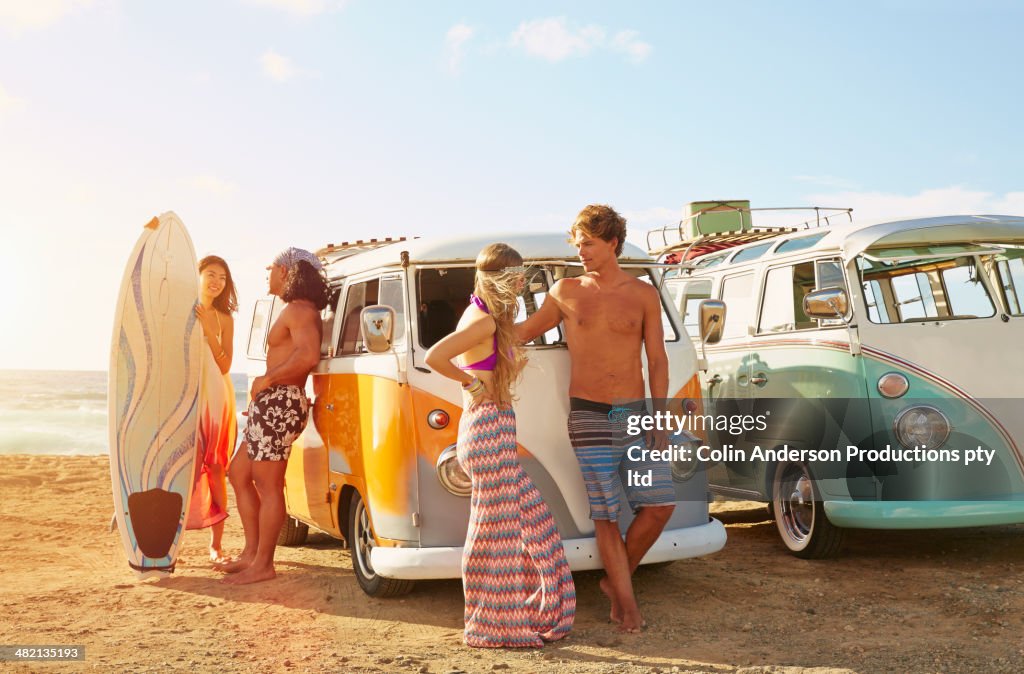 Friends with vans parked on beach