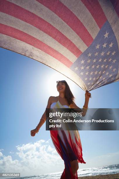 japanese woman holding american flag on beach - american flag beach stock pictures, royalty-free photos & images