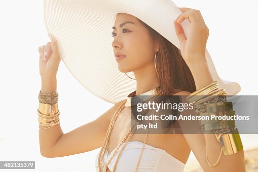 Japanese woman wearing gold bracelets and sun hat Japanese woman wearing gold bracelets and sun hat