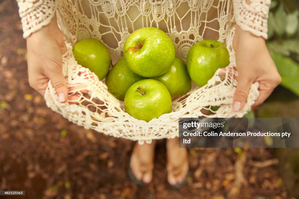 Caucasian woman holding apples in dress