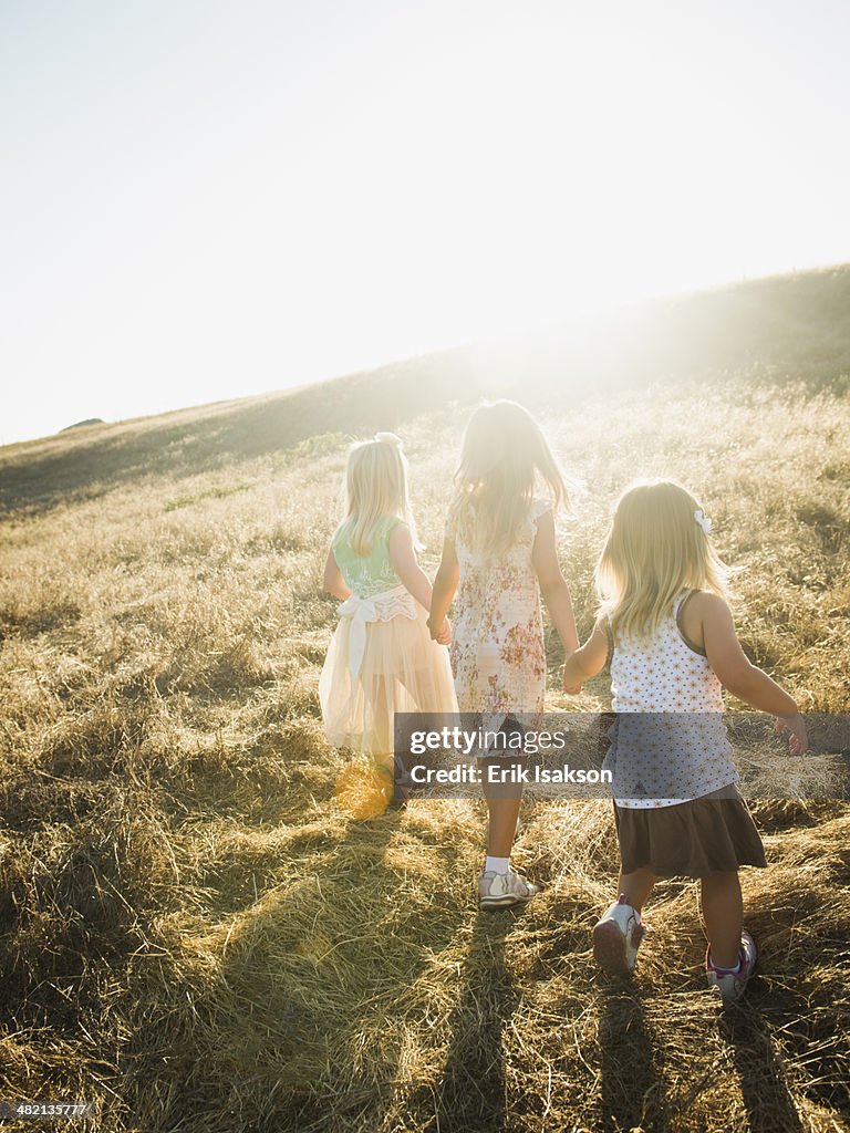 Children holding hands in rural field
