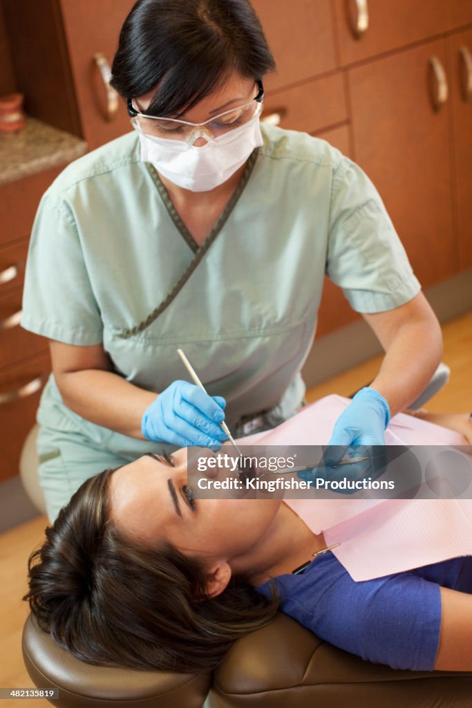 Dental nurse examining patient's teeth