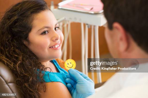 dentist giving patient smiley face sticker - kids with cleaning rubber gloves 個照片及圖片檔