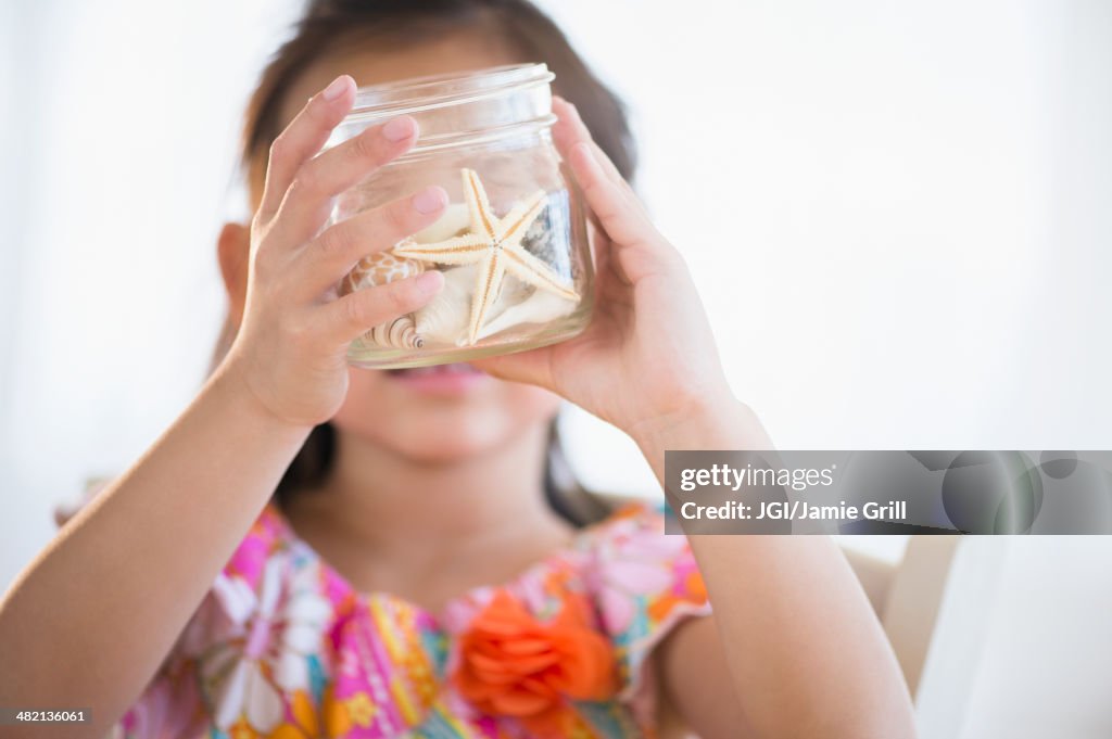 Korean girl examining starfish in jar