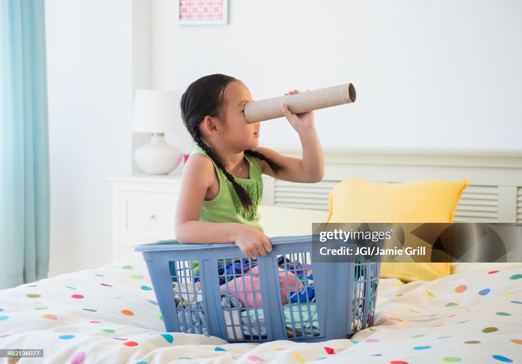 Korean girl looking through cardboard tube