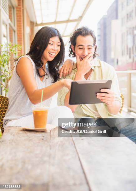 couple using digital tablet at sidewalk cafe - tablet paar sommer stock-fotos und bilder