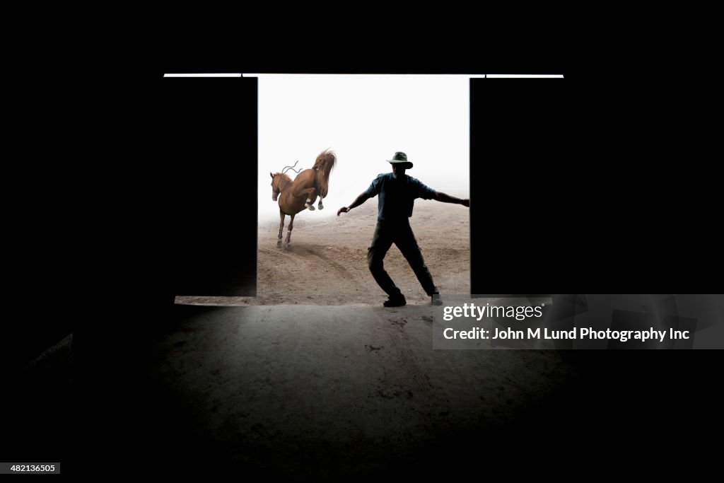 Caucasian rancher closing barn door