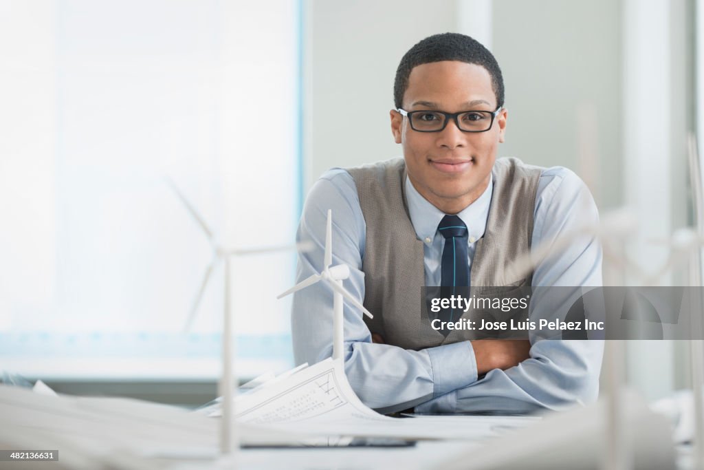 Businessman smiling with wind turbine models