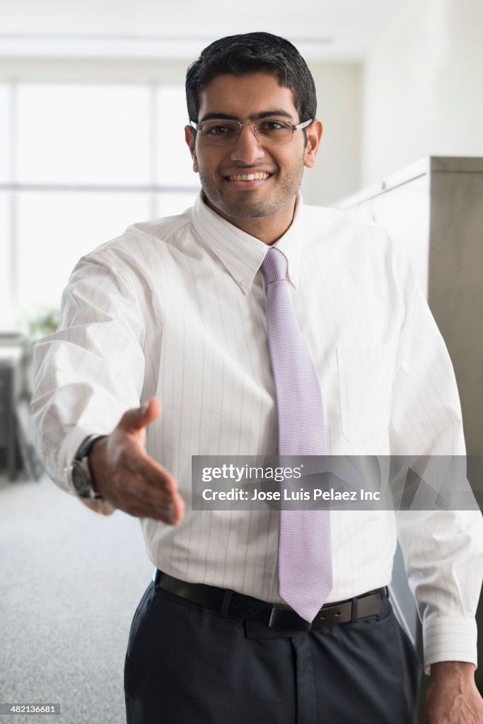 Indian businessman extending handshake in office
