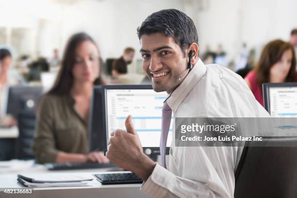 indian businessman giving thumbs up in office - computer headset stock pictures, royalty-free photos & images