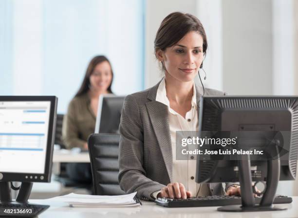 businesswoman wearing headset at desk - answering email stock pictures, royalty-free photos & images