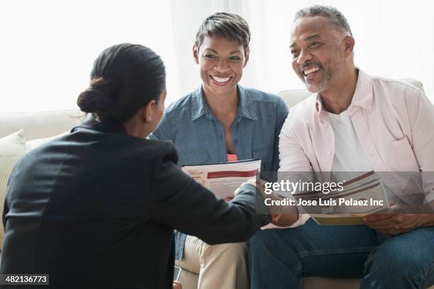 african american couple talking to businesswoman - accountant stockfoto's en -beelden
