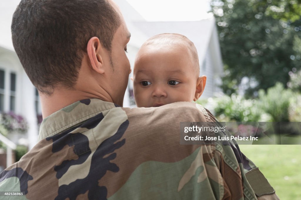 Returning soldier greeting baby