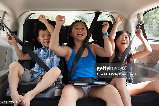 chinese children cheering in backseat of car - girl in car with ipad stock pictures, royalty-free photos & images