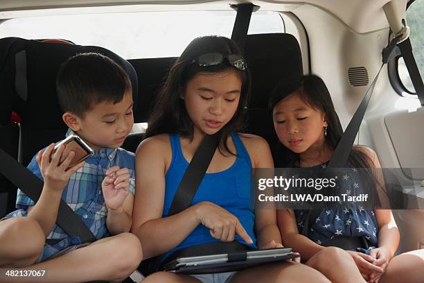 chinese children using digital tablet in backseat of car - child car tablet ストックフォトと画像