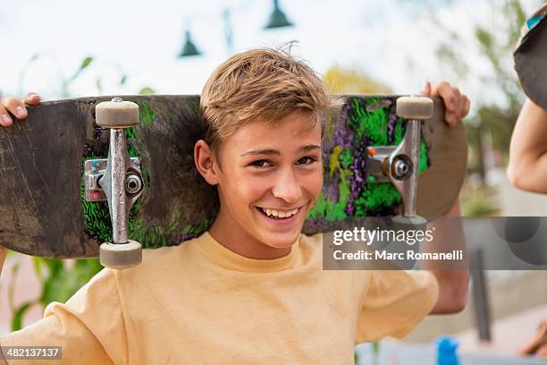 caucasian boy holding skateboard outdoors - boy happy blonde stock pictures, royalty-free photos & images