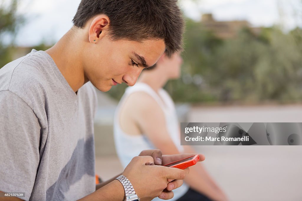 Caucasian boy using cell phone outdoors