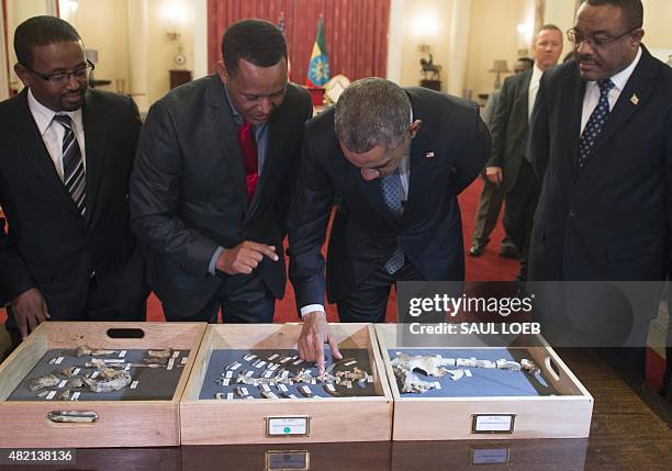 President Barack Obama touches a bone fragment of "Lucy", who was estimated to have lived 3,2 million years ago, alongside Ethiopian Prime Minister...