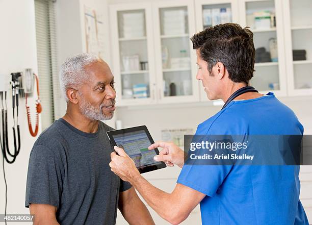 nurse talking to patient in doctor's office - medicare krankenversicherung stock-fotos und bilder