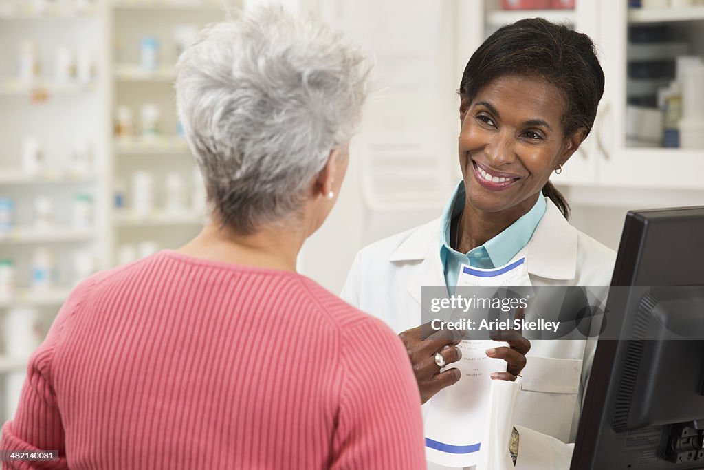 Pharmacist serving customer in pharmacy